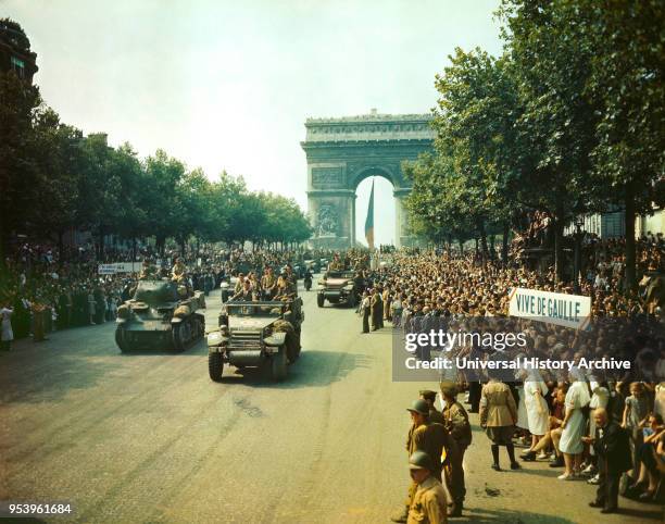 Crowds of French Patriots line Champs Elysees to view Allied Tanks and half tracks pass through the Arc du Triomphe after Paris, France was Liberated...