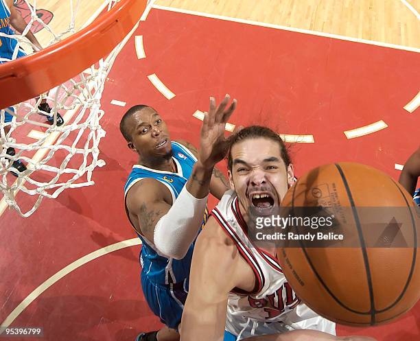 Joakim Noah of the Chicago Bulls jumps towards the ball as Julian Wright of the New Orleans Hornets comes up from behind during the NBA game on...