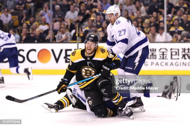 David Pastrnak of the Boston Bruins falls over Steven Stamkos of the Tampa Bay Lightning during the first period Game Three of the Eastern Conference...