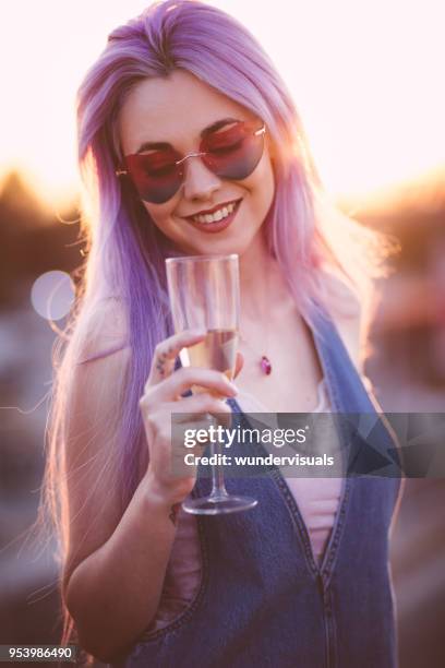 hipster-frau mit lila haaren trinken champagner am sommerfest - purple hair stock-fotos und bilder