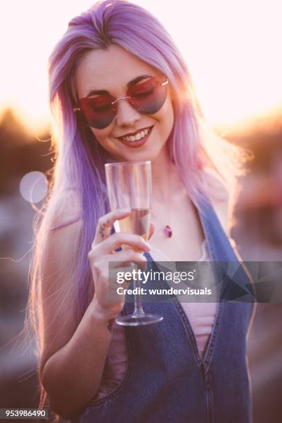 mujer hipster con pelo púrpura bebiendo champagne en la fiesta de verano - cabello morado fotografías e imágenes de stock