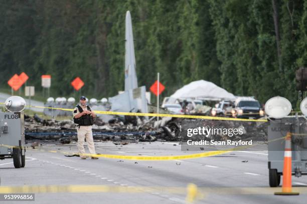 An emergency responder stands on Route 21 where an Air National Guard C-130 cargo plane crashed May 2, 2018 in Port Wentworth, Georgia. The...