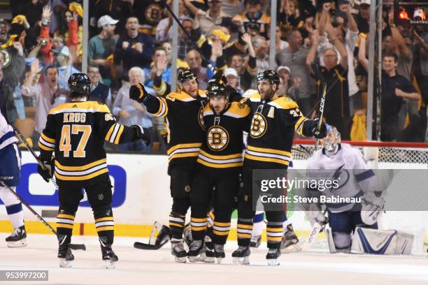 Torey Krug, David Pastrnak, Brad Marchand and Patrice Bergeron of the Boston Bruins celebrate the goal against the Tampa Bay Lightning in Game Three...