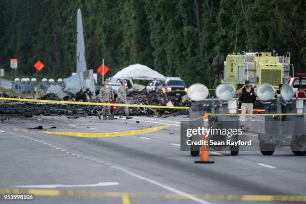 Emergency responders walk across Route 21 where an Air National Guard C-130 cargo plane crashed May 2, 2018 in Port Wentworth, Georgia. The...