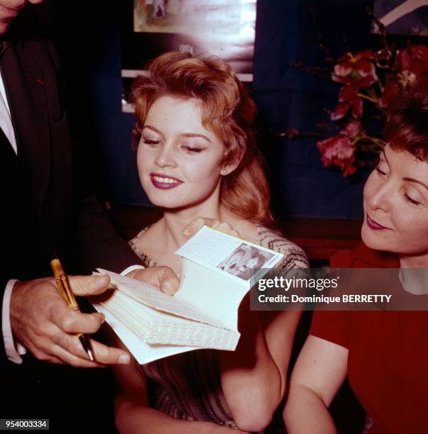 Les actrices française Brigitte Bardot et Odette Joyeux pendant un séance de dédicades du livre ?La Mariée ingénue?, à Paris, en 1956, France.