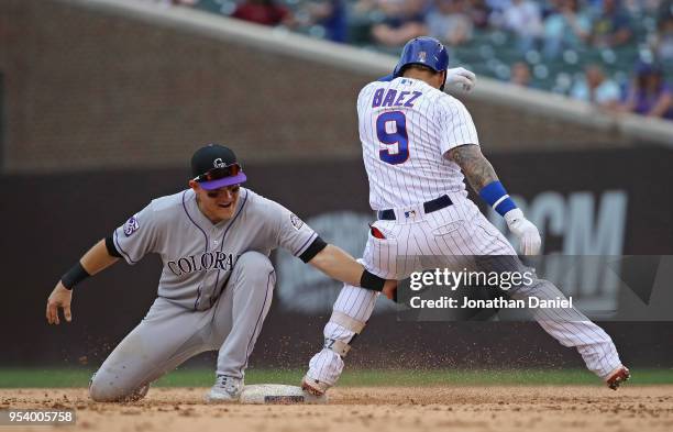 Javier Baez of the Chicago Cubs gets back to second base before the tag attempt by Pat Valaika of the Colorado Rockies at Wrigley Field on May 2,...