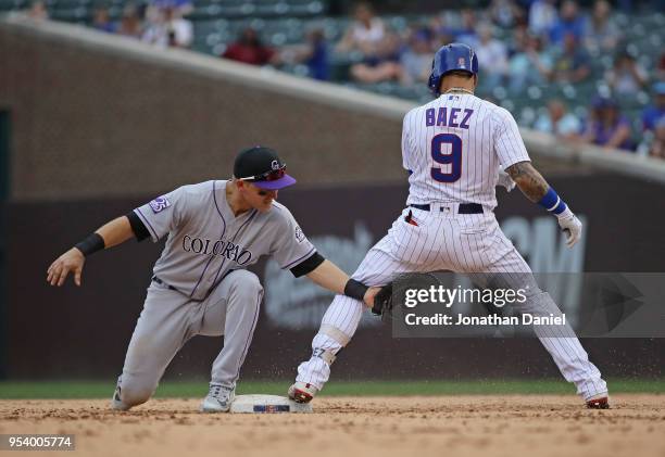 Javier Baez of the Chicago Cubs gets back to second base before the tag attempt by Pat Valaika of the Colorado Rockies at Wrigley Field on May 2,...