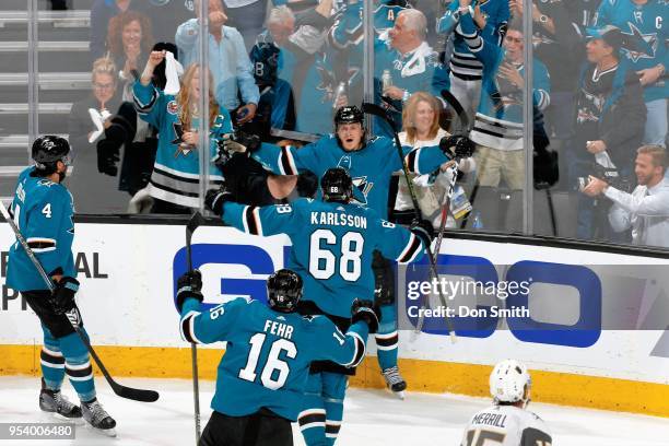 Brenden Dillon, Eric Fehr and Melker Karlsson of the San Jose Sharks go to congratulate Marcus Sorensen of the San Jose Sharks on his first period...