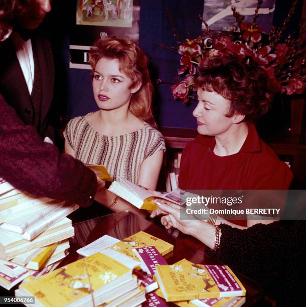 Les actrices française Brigitte Bardot et Odette Joyeux pendant un séance de dédicades du livre ?La Mariée ingénue?, à Paris, en 1956, France.