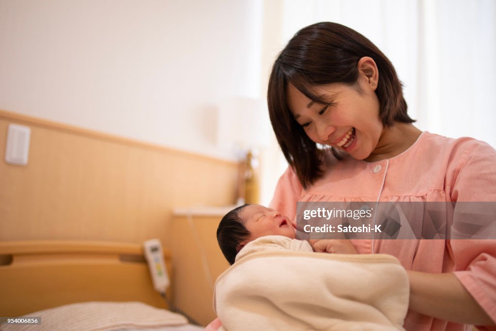 新しい生まれた赤ちゃんと母の病院に笑みを浮かべて