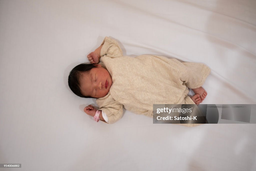 Newborn baby sleeping on bed