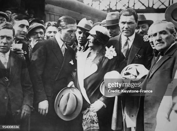 Le boxeur Georges Carpentier photographié avec le joueur de football américain Franck Dempsey et son épouse à leur arrivée à Paris, France.