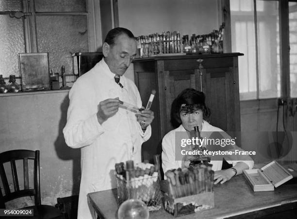 Monsieur Vaudremer et Mademoiselle Brun qui ont découvert le moyen de cultiver la bacille de la peste, photographiés dans leur laboratoire, à Paris,...