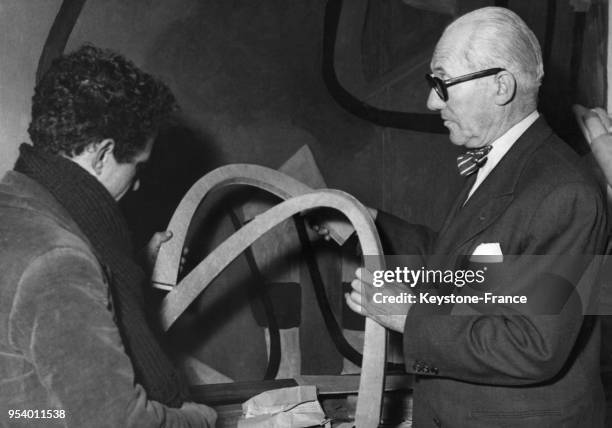 Le Corbusier explique à un de ses collaborateurs les raisons de la forme spéciale des éléments du plancher de l'unité d'habitation qui va être...