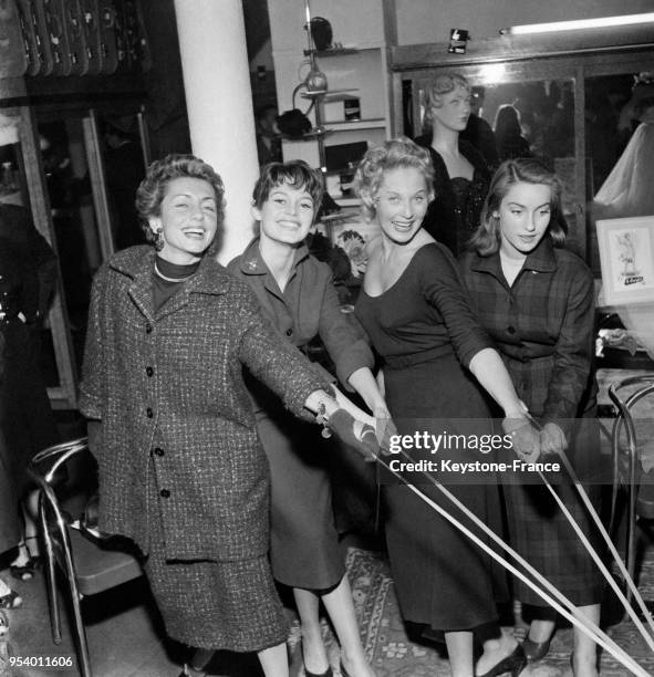 Brigitte Bardot, Tilda Thamar et Estella Blain, testant des bas dans un grand magasin parisien, à Paris, France, le 1er octobre 1954.