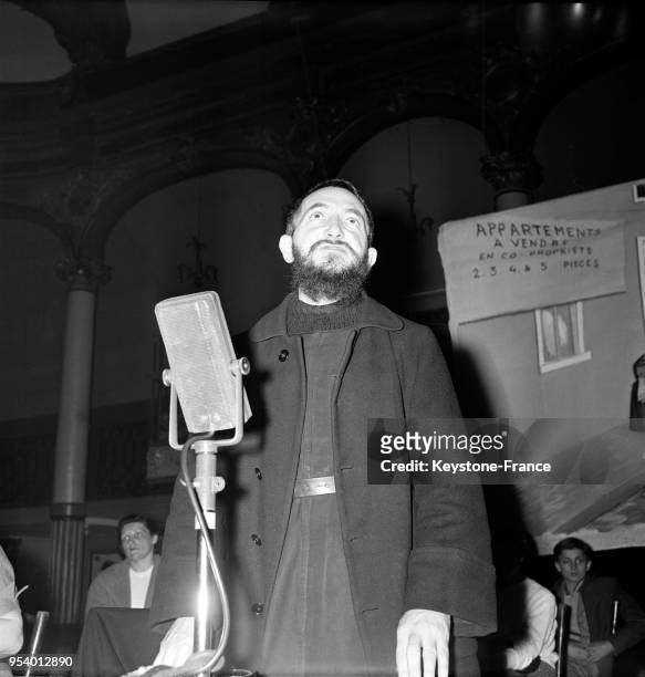 Abbé Pierre lors du meeting organisé par l'Aide aux sans-logis de la région parisienne à la salle Wagram à Paris, France, le 10 avril 1956.