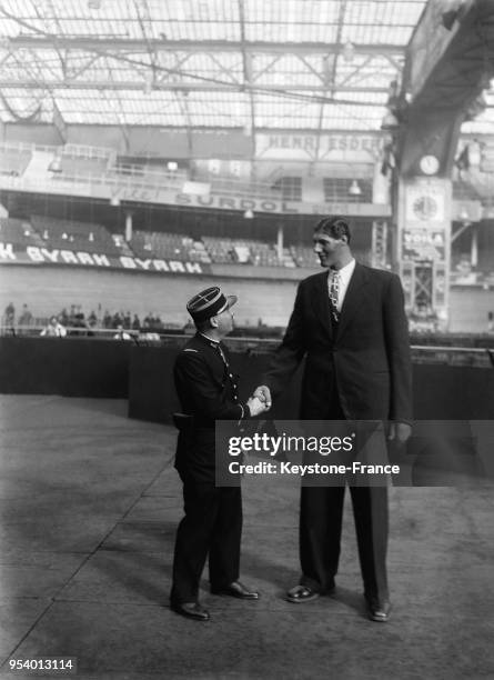 Le géant roumain Gogea Mitu serre la main d'un agent de service au Palais des Sports lors de sa visite aux 'Six Jours', à Paris, France en novembre...