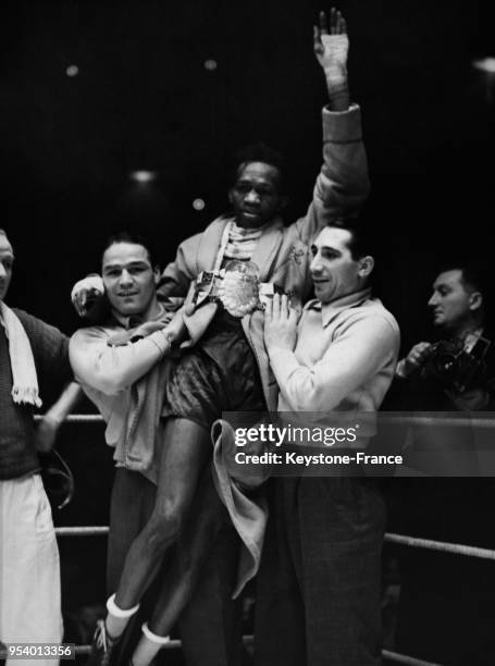 Le boxeur noir panaméen Al Brown porté en triomphe après la reconquête de son titre de champion du monde contre l'Espagnol Sangchili au Palais des...