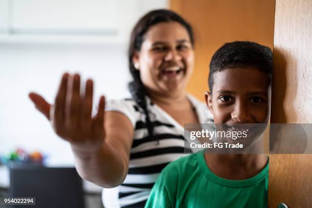 mère et fils accueillant et ouverture de porte - panneau de bienvenue photos et images de collection