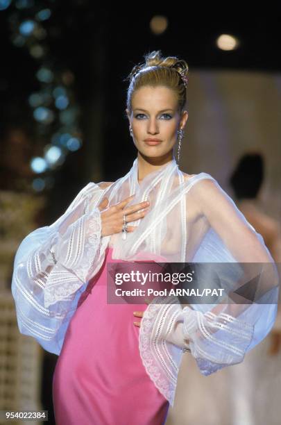 Karen Mulder porte une blouse transparente avec une jupe taille haute rose lors du défilé Dior Haute Couture Printemps/Eté, janvier 1995, à Paris,...