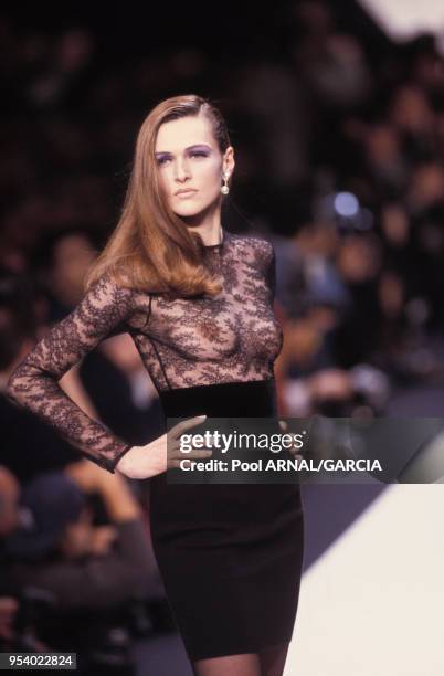 Sylvie Gueguen porte une jupe courte avec un haut de dentelle transparent noir au défilé Dior Haute Couture Printemps/Eté en janvier 1995 à Paris,...