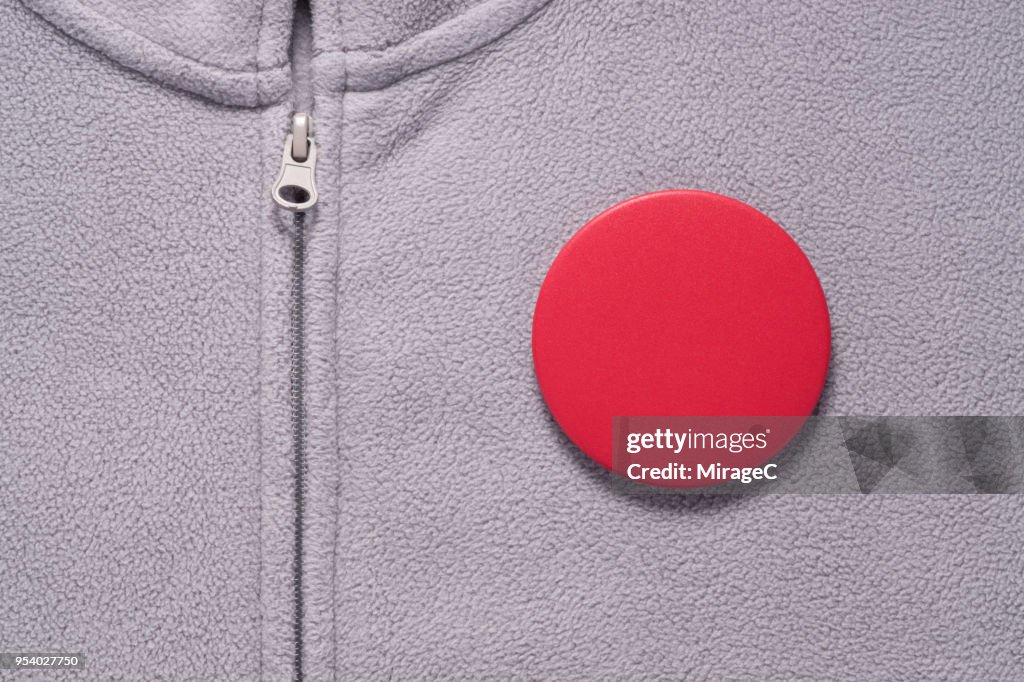 Red Button Badge on Gray Cloth