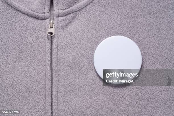 white button badge on gray cloth - spilla foto e immagini stock