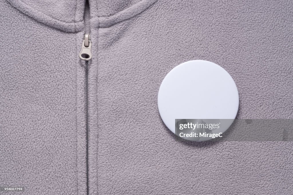 White Button Badge on Gray Cloth