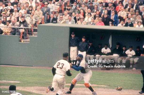 Felipe Alou of the San Francisco Giants slides home as catcher John Roseboro of the Los Angeles Dodgers waits to receive the ball during an MLB game...