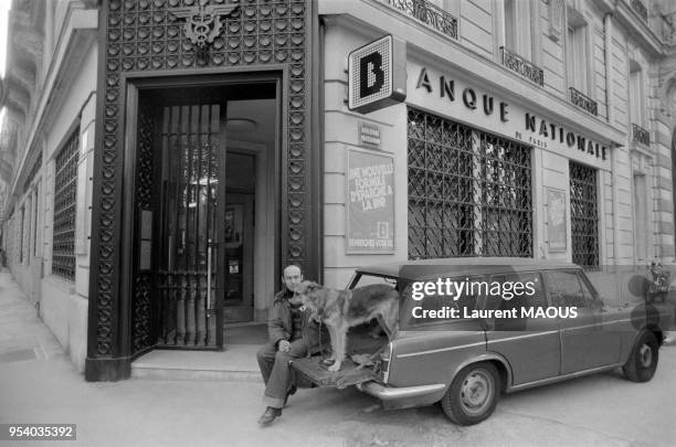 Une banque surveillée par un vigile et son chien en octobre 1978 à Paris, France.