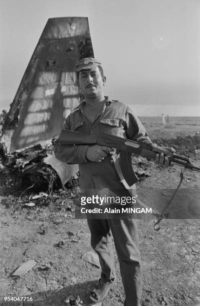 Soldat irakien posant devant un avion de cahhse F5 iranien abattu près de bassora en september 1980, Irak.