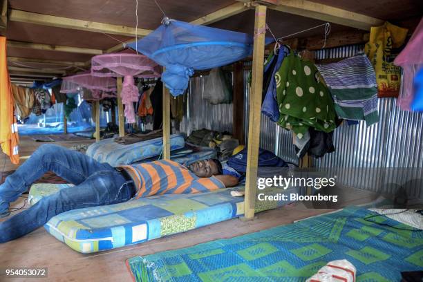 Worker rests in a make-shift boarding house for construction workers in Colombo, Sri Lanka, on Saturday, March 31, 2018. Cranes loom over the skyline...