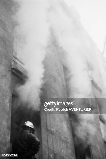 Sapeur-pompier tentant d'éteindre un incendie en juin 1982 à Paris, France.