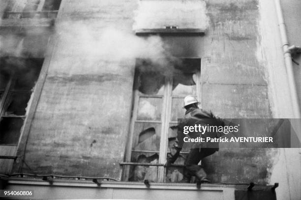 Sapeur-pompier tentant d'éteindre un incendie en juin 1982 à Paris, France.