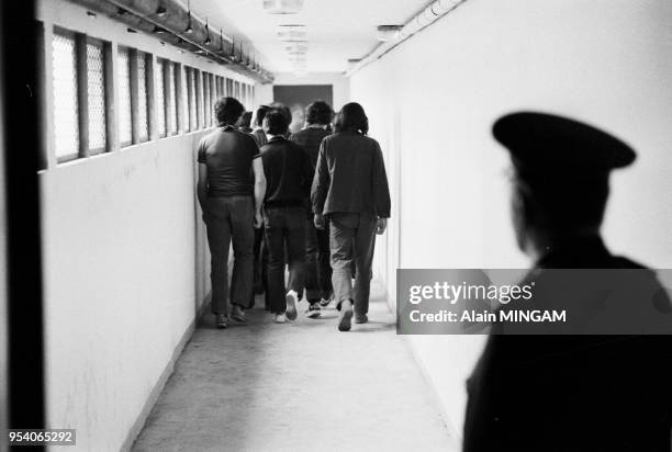 Gardien surveillant des détenus dans un couloir de la prison moderne de Lorient en mars 1983, France.