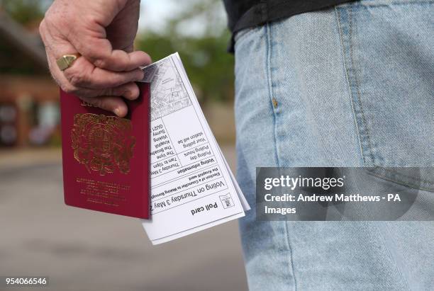 Voter carries his passport along with his poll card, as he makes his way to vote at The Vyne polling station in Knaphill, part of the Woking borough,...