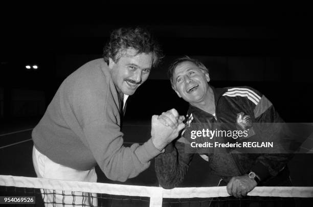 Le comédien Victor Lanoux et l'entraîneur de football Michel Hidalgo jouent au bras de fer le 10 janvier 1985 aux Menuires, France.