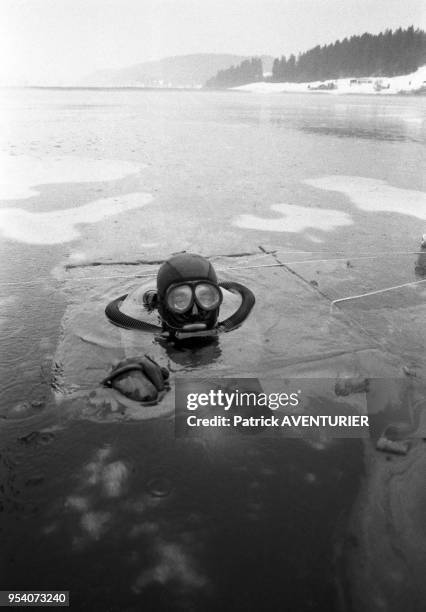 Un plongeur du Groupe d'Intervention de la Gendarmerie Nationale lors d'un entrainement en hiver dans le lac gelé de Malbuisson en janvier 1985,...