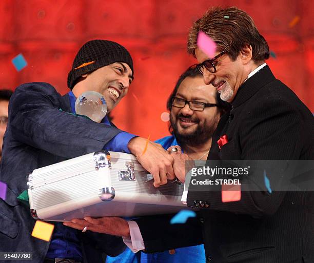 Indian actor and television host Amitabh Bachchan hands over a prize to winner Vindu Dara Singh at a ceremony to mark the end of the current season...