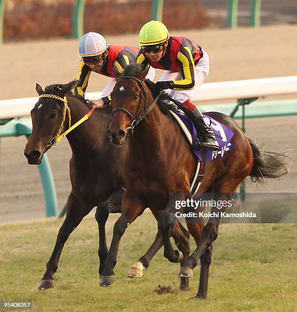 Jockey Kenichi Ikezoe aboard Dream Journey leads jockey Norihiro Yokoyama aboard Buena Vista across the line to win in the 54th Arima Kinen at...