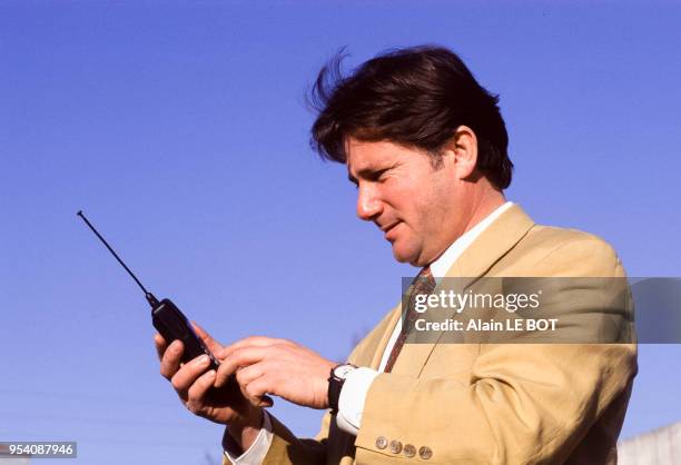 Un homme compose un numéro sur son téléphone portable en mars 1997 à Nantes, France.