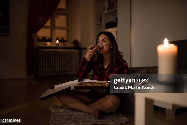 hungry woman having a slice of pizza - unhealthy living stock pictures, royalty-free photos & images