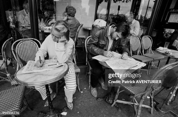 Une femme et un homme lisent les petites annonces à la recherche d'un emploi à Paris en septembre 1985, France.