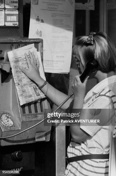 Une femme à la recherche d'un emploi téléphone en réponse à une petite annonce à Paris en septembre 1985, France.