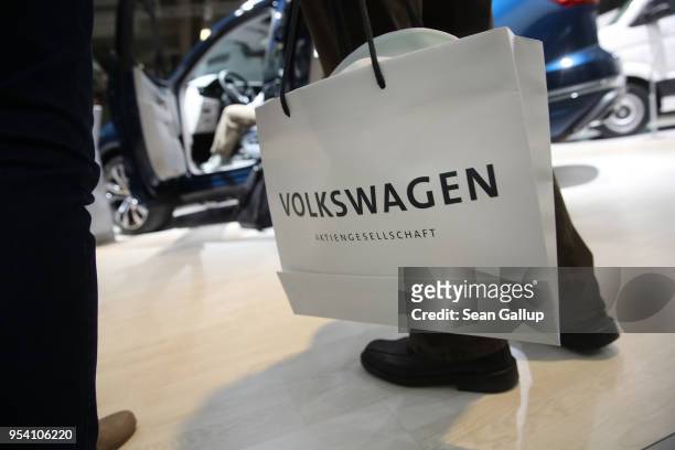 An elderly shareholder of German car manufacturer Volkswagen AG carries a Volkswagen goody bag at Volkswagen's annual general shareholders' meeting...