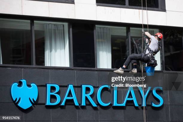 Window cleaner suspended from ropes cleans a window above a bank branch of Barclays Plc in London, U.K., on Thursday, May 3, 2018. Barclays Plc is...