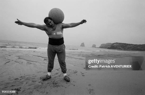 Jeune paysan basque s'entrainant avec un boulet en pierre lors de jeux de forces aux Pays-Basque en février 1987, France.