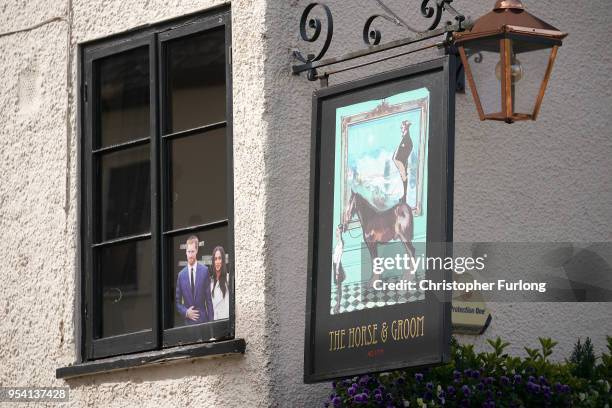 Photograph of Britain's Prince Harry and his fiance US actress Meghan Markle is displayed in the window of the Two Brewers Pub on May 3, 2018 in...