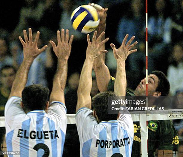 Gavio Fiovane from Brazil returns the ball against Argentinian Jorge Elgueta and Gustavo Porporato's defense, 02 August 2002 in Rosario, Argentina....