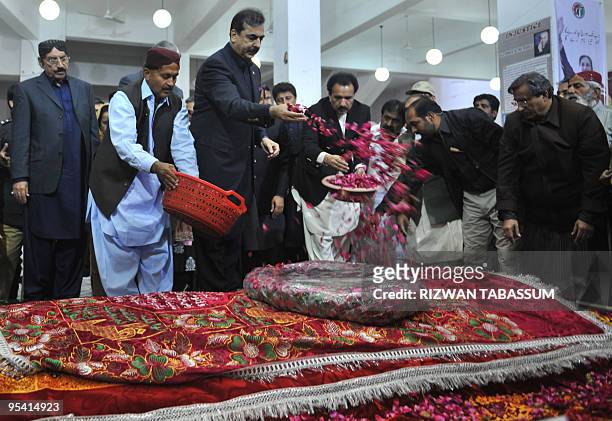 Pakistani Prime Minister Yousuf Raza Gilani showers rose petals on the grave of slain former premier Benazir Bhutto on her second death anniversary...